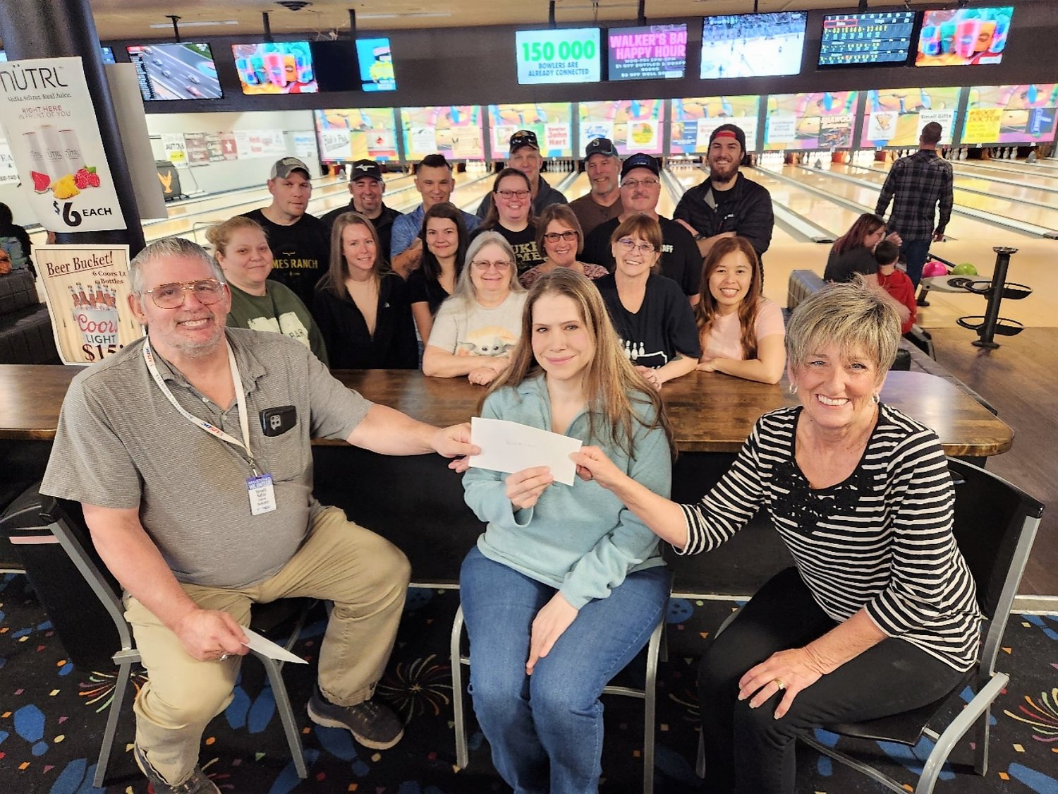 Ron Keller, left, and Barbara Overlin, right, co-chairs for the Cancer Care and Humane Society Bowling Tournament, present Jennifer Jackson, annual giving officer with Providence Southwest Washington Foundation, with a donation check for the Cancer Care Fund. Behind them are the winners from the bowling tournament.